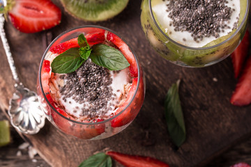 Healthy breakfast or morning snack with chia seeds granola, strawberries and kiwi, vegetarian food, diet and health concept