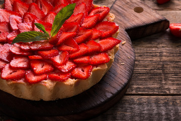 Tart with strawberries and whipped cream on wooden vintage table