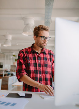 Young Man Working On Computer In Office