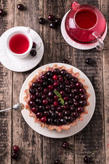 Tart with cherry and whipped cream on wooden vintage table