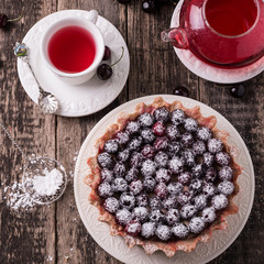 Tart with cherry and whipped cream on wooden vintage table