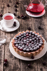 Tart with cherry and whipped cream on wooden vintage table