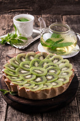 Tart with kiwi and whipped cream on wooden vintage table
