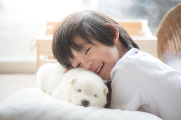 asian child playing with siberian husky puppy