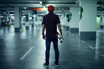 Rear view of skateboarder holding his longboard