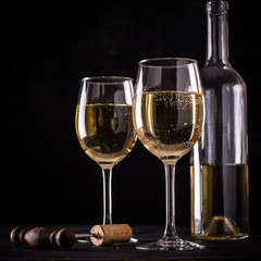 White wine still life in vintage style on black background