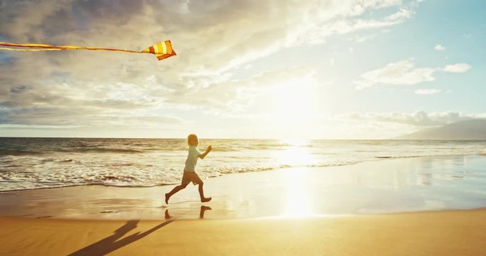 Young boy playing with kite on the beach