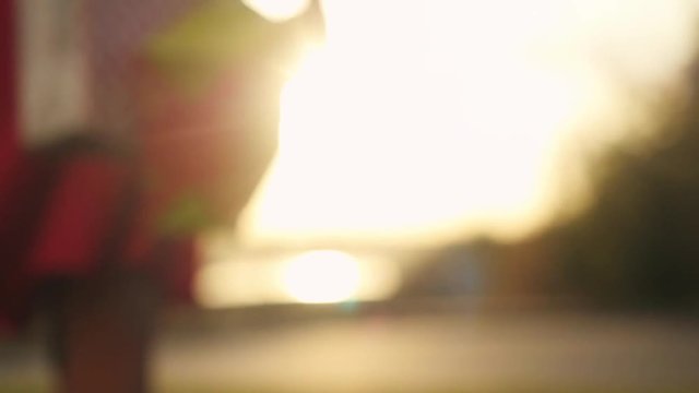 Blurred shopaholic in beautiful dress holding many shopping bags walking on the street through the sun during sunset in slowmotion. 1920x1080