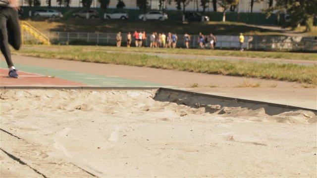 Male athlet lands into the sandpit