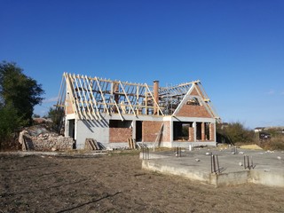 New house under construction with wooden frame of a roof