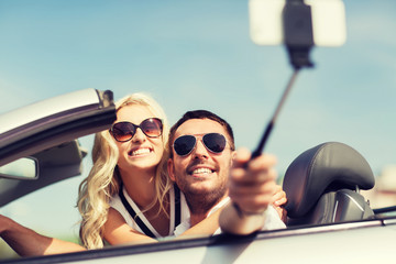 happy couple in car taking selfie with smartphone