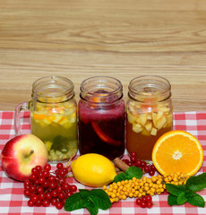 Hot autumn drinks in Mason jars in the composition of fruit, berries, branches and twigs viburnum buckthorn. Background with a copy space.