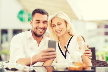 happy couple taking selfie with smatphone at cafe