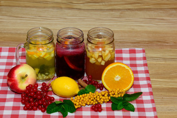 Fototapeta na wymiar Hot autumn drinks in Mason jars in the composition of fruit, berries, branches and twigs viburnum buckthorn 
