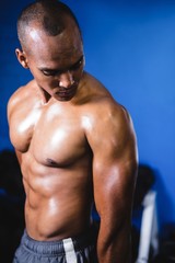 Fototapeta na wymiar Muscular man looking at arm in gym