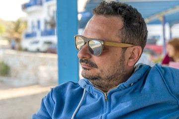 Young man drinking coffee in Naxos island, Cyclades, Greece duri