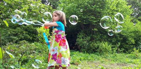 Kleines Mädchen macht große Seifenblasen