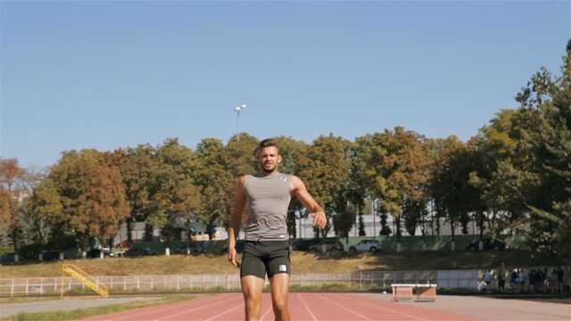 Male athlet injures his leg on the runway at the stadium