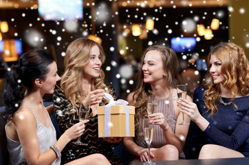 Plakat happy women with champagne and gift at night club