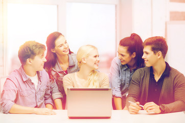 smiling students with laptop at school