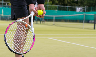 Male player's hand with tennis ball preparing to serve