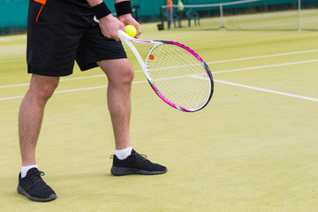 Close up male player's hand with tennis ball getting ready to se