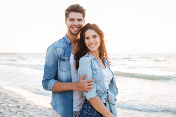 Smiling young couple standing at the beach