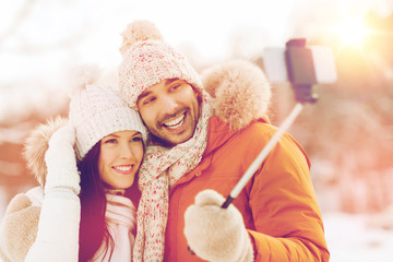 Fototapeta premium happy couple taking selfie by smartphone in winter