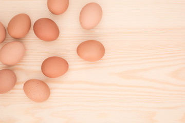 eggs on light brown wood background, top view