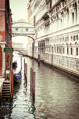 Photo of the Bridge of Sighs (Ponte dei Sospiri ) with gondolas dock in Venice (Italy). Photo is edited as a vintage with dark edges.