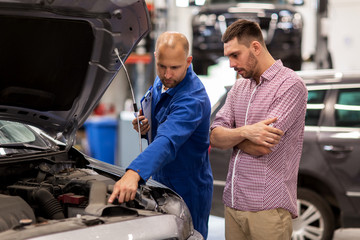 auto mechanic with clipboard and man at car shop