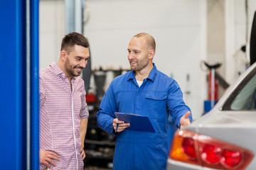 auto mechanic with clipboard and man at car shop