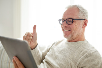 senior man having video call on tablet pc at home
