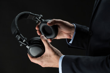 close up of businessman hands holding headphones