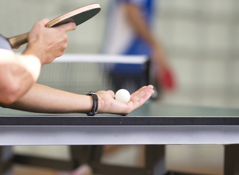 table tennis player serving, focus at the ball, small depth of field