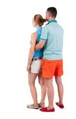 Back view of young embracing couple in shorts  hug and look. friendly girl and guy together. Rear view people collection. backside view of person.  Isolated over white background.