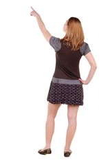 Beautiful young woman looking at wall. Rear view. Isolated over white.