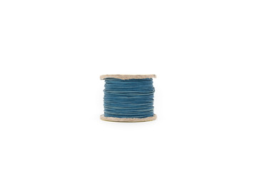 spool of dyed blue thread on white background