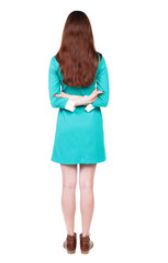 back view of standing young beautiful  woman.  girl  watching. Rear view people collection.  backside view of person.  Isolated over white background. The girl in a blue dress with brown shoes is hand