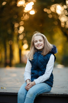 Cute Teenager girl walks in Autumn park. Sunny day, selective focus