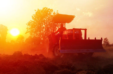 Agriculture in Thailand, a tractor plowing soil field