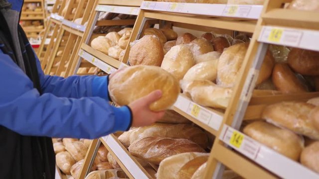 guy choose fresh baked goods in the supermarket