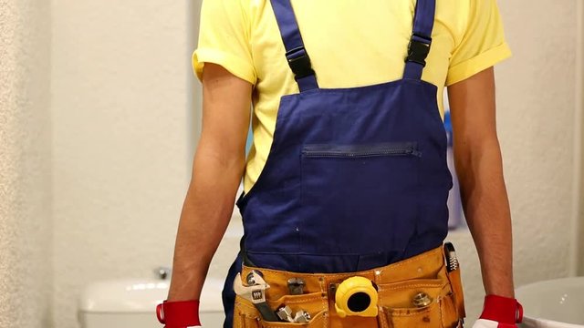 plumber with tool box standing in bathroom ready to work