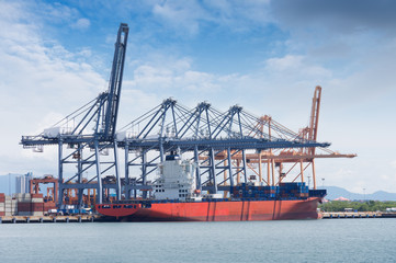 Logistics and transportation of International Container Cargo ship with ports crane bridge in harbor for logistic import export background and transport industry...