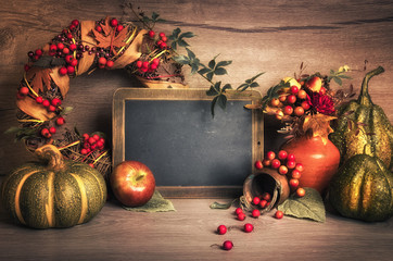 Autumn decorations on wood and chalkboard, text space