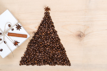 Christmas tree made from coffee beans and gift box on wooden bac