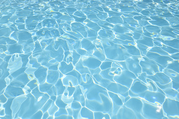 Ripple blue water in swimming pool with sun reflection