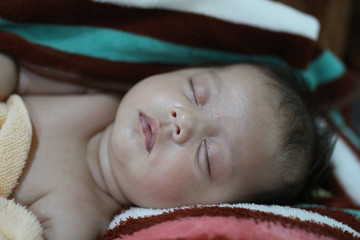Baby girl wrapping infants in cloths in order to prevent limb mo