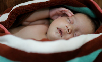 Baby girl wrapping infants in cloths in order to prevent limb mo