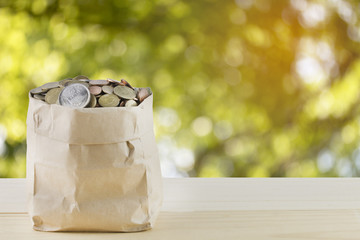 bag of coins with abstract nature bokeh blur background.